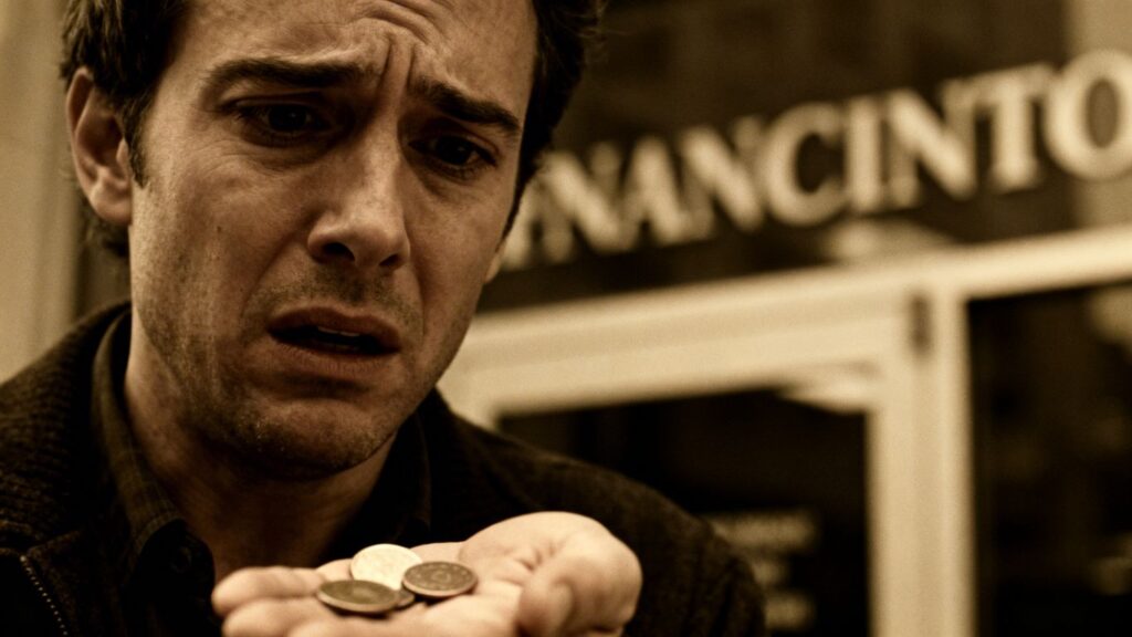 Persona preocupada buscando dinero con pocas monedas.